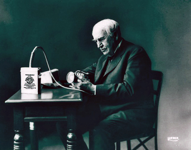 Image of Thomas Edison with his battery powered cap lamp