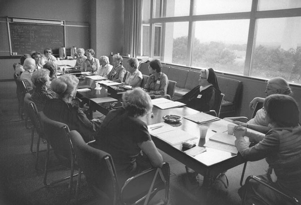 Eighteen women with PhD’s in Mathematics seated at a table at the museum in 1981.