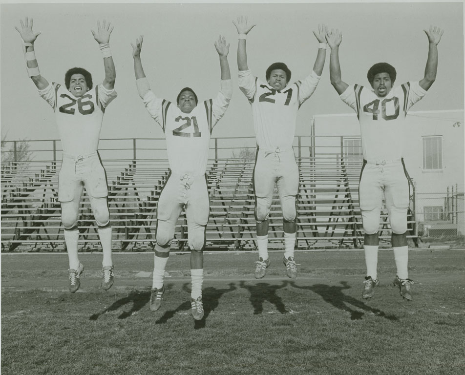 Photo of four football players jumping, Howard University , 1940s